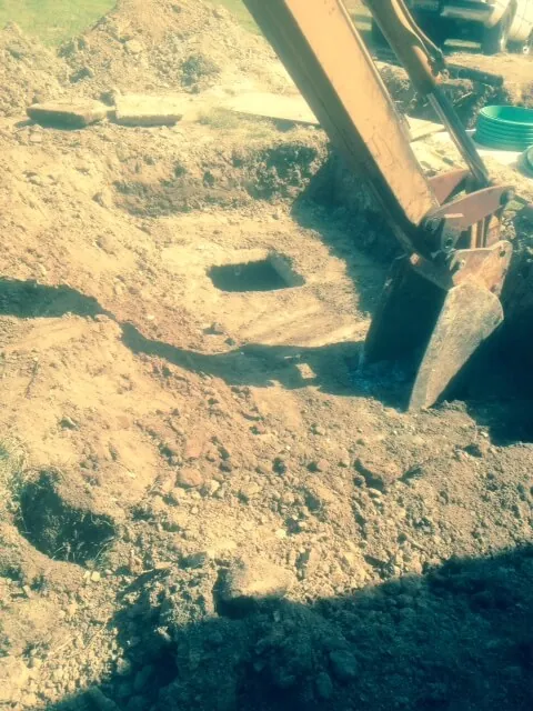 Excavator digging out a septic system